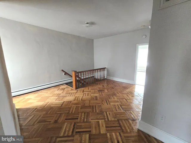 a view of empty room with wooden floor