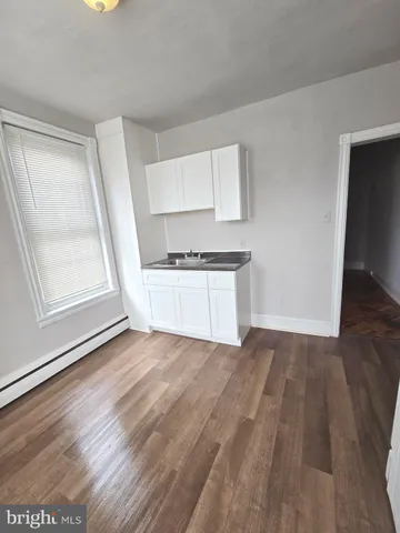 a view of a kitchen with wooden floor and electronic appliances