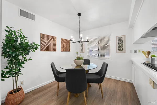 a dining room with furniture potted plants and wooden floor