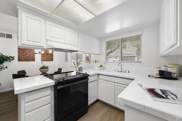 a kitchen with granite countertop a sink stove and cabinets