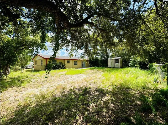 a view of a house with large trees