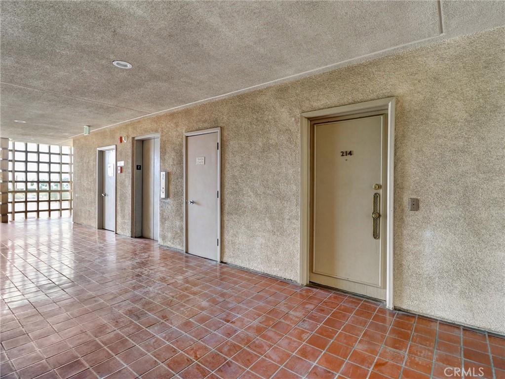 277 East Alejo Road, Unit 214 Palm Springs, CA 92262 - Photo 14 of 17 a view of a hallway with wooden floor and a bathroom