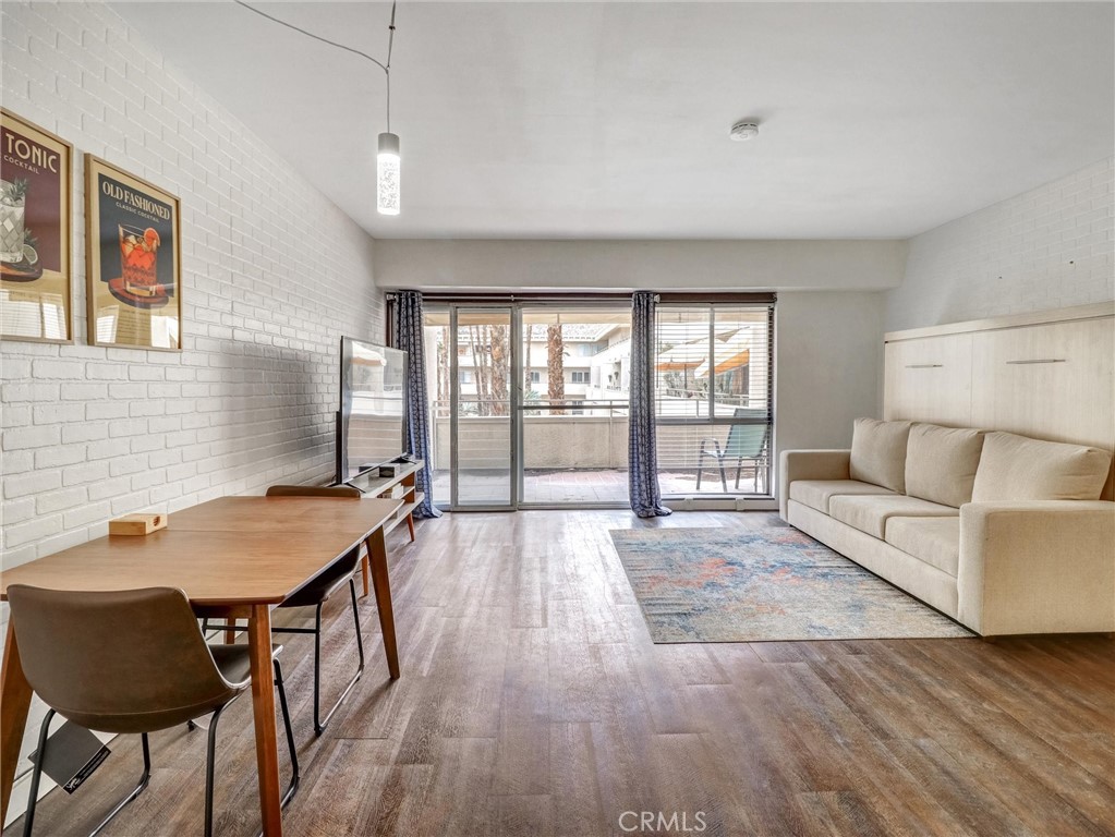 277 East Alejo Road, Unit 214 Palm Springs, CA 92262 - Photo 2 of 17 a living room with furniture and wooden floor