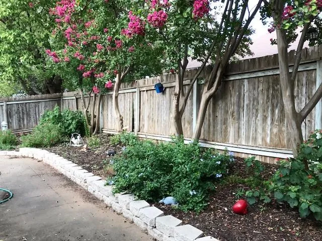 a backyard of a house with flower plants
