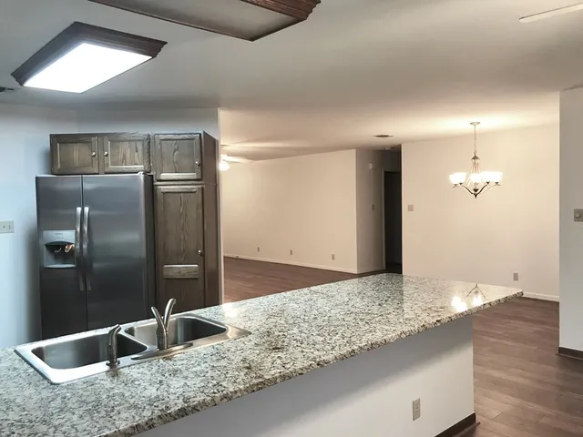 a kitchen with stainless steel appliances granite countertop a sink and a refrigerator