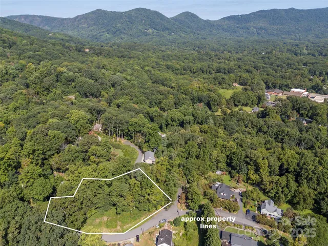 an aerial view of a residential houses with yard