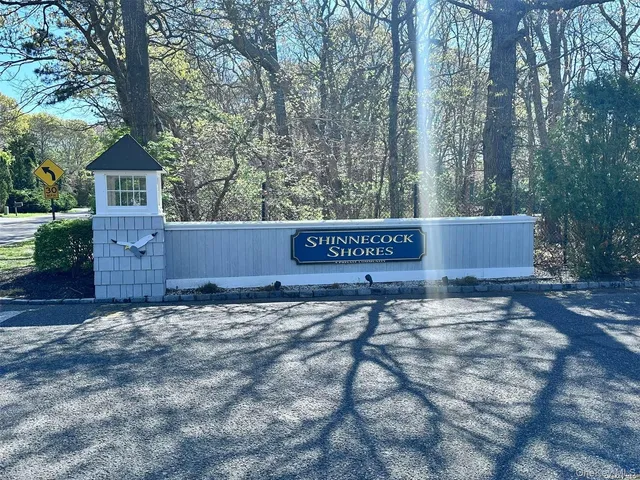a view of a house with a yard and tree in the background