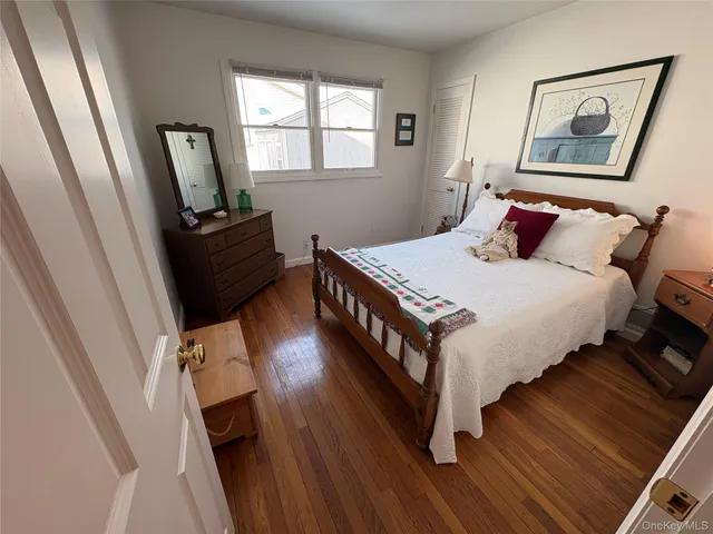 a bedroom with bed and wooden floor