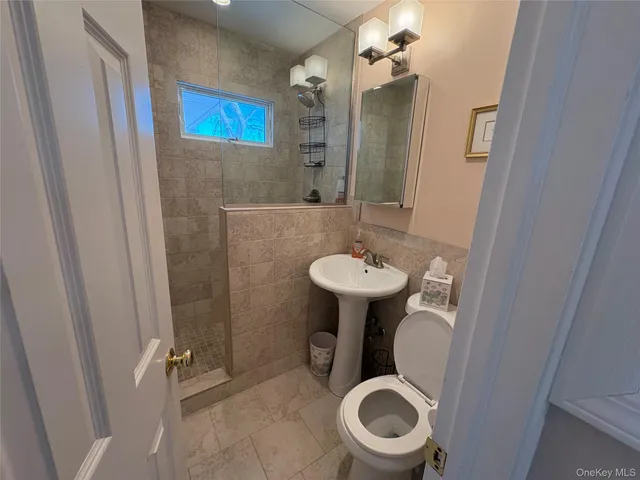a bathroom with a sink toilet and a mirror