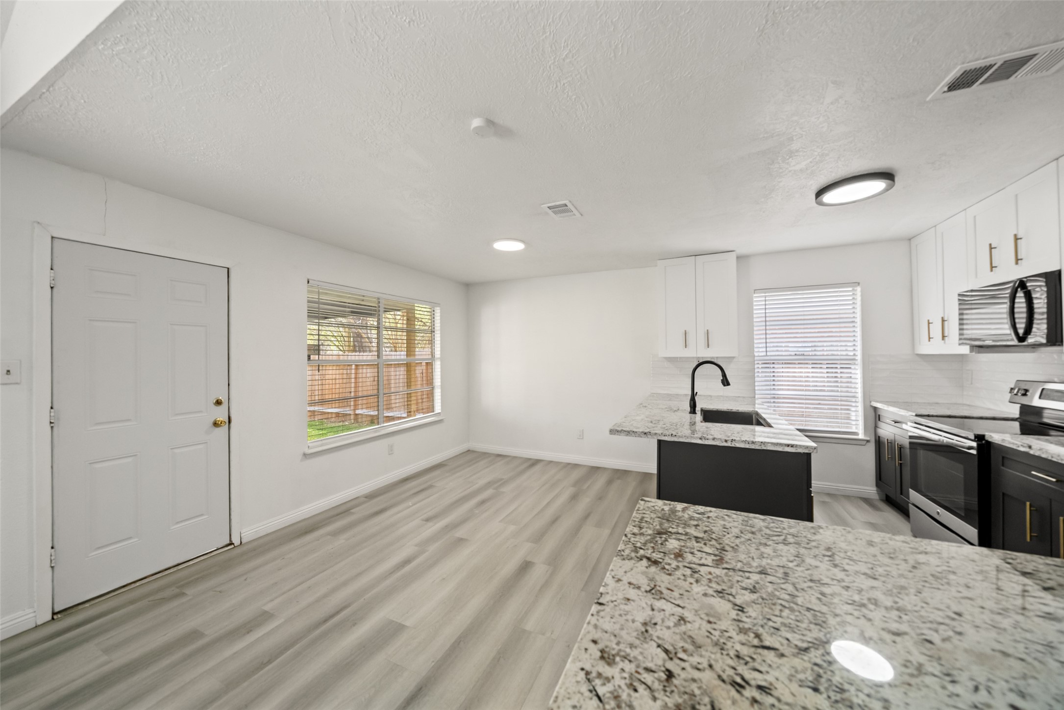 5726 Yorkgate Drive Spring, TX 77373 - Photo 8 of 20 a living room with stainless steel appliances kitchen island granite countertop a sink and wooden floor