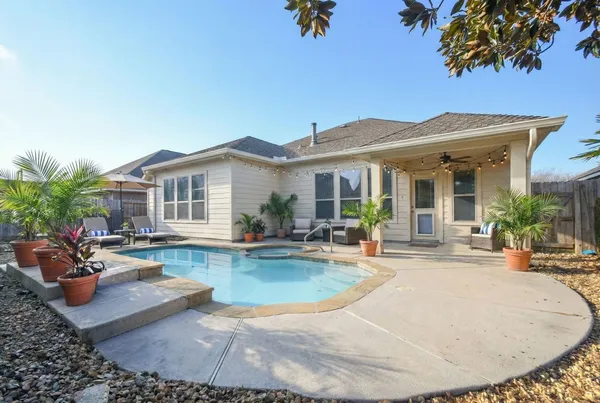a view of a house with swimming pool and sitting area