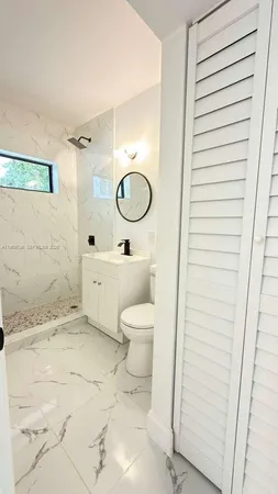 a bathroom with a toilet sink vanity and mirror