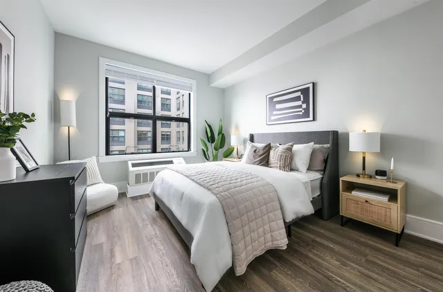 a bedroom with a bed and a large window