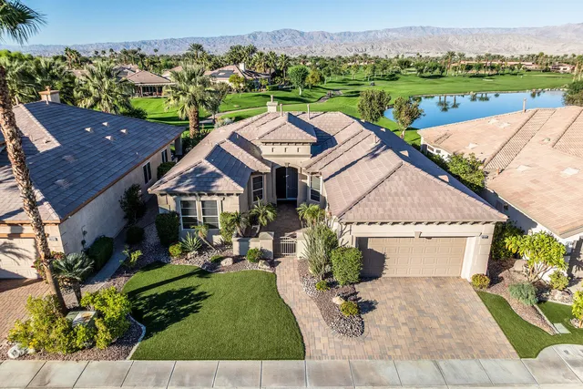 an aerial view of a house with a garden and lake view