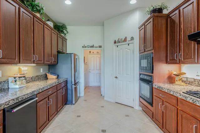 a kitchen with stainless steel appliances granite countertop a stove and a wooden cabinets