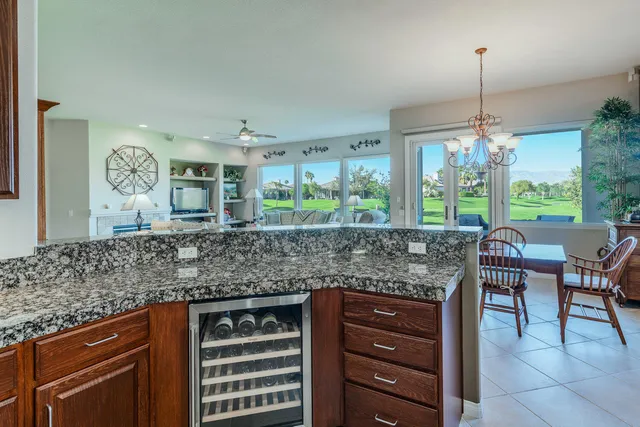 a kitchen with granite countertop a sink a stove and cabinets
