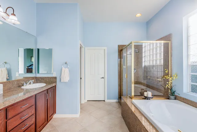 a en suite bathroom with a granite countertop sink mirror and vanity