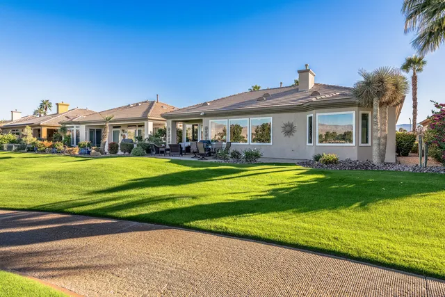 a view of a patio with table and chairs potted plants and large tree