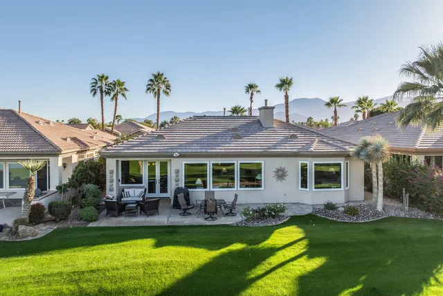 a view of a swimming pool with a patio and a yard