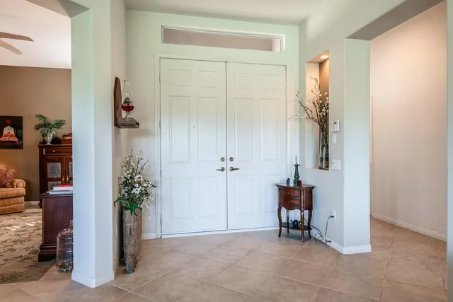 an entryway with a flower pot and a bookshelf