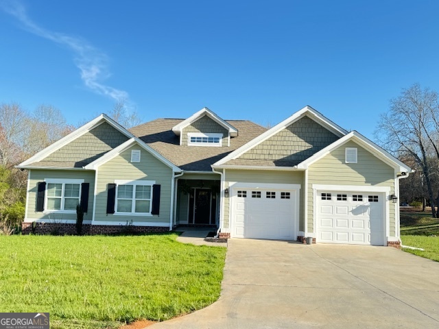 a front view of a house with a garden and yard
