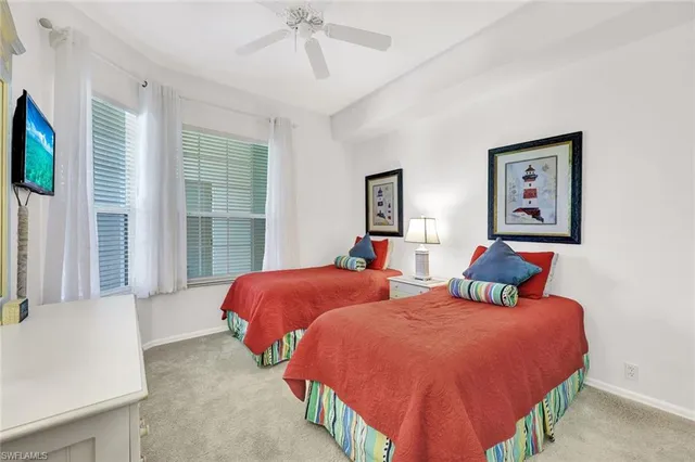 a bedroom with two beds and a window