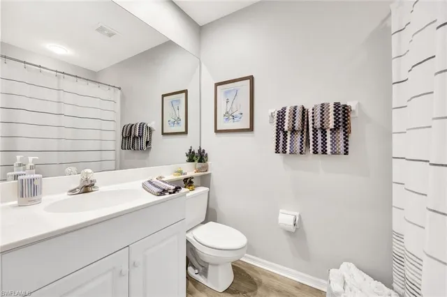 a bathroom with a granite countertop toilet sink and mirror