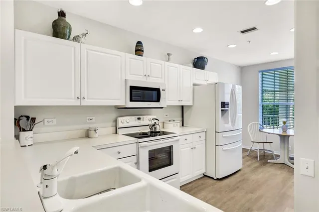 a kitchen with white cabinets and white appliances