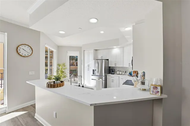 a kitchen with white cabinets and stainless steel appliances