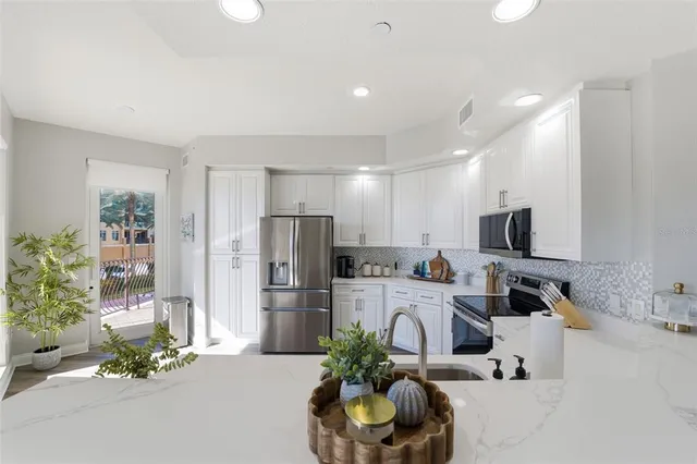 a kitchen with refrigerator a microwave and cabinets