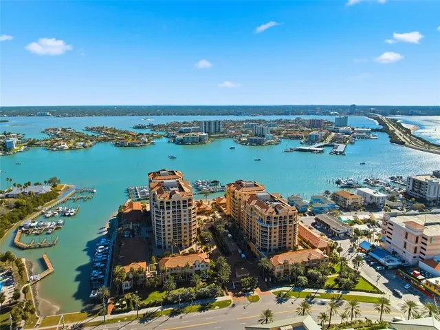 an aerial view of ocean and residential houses with outdoor space