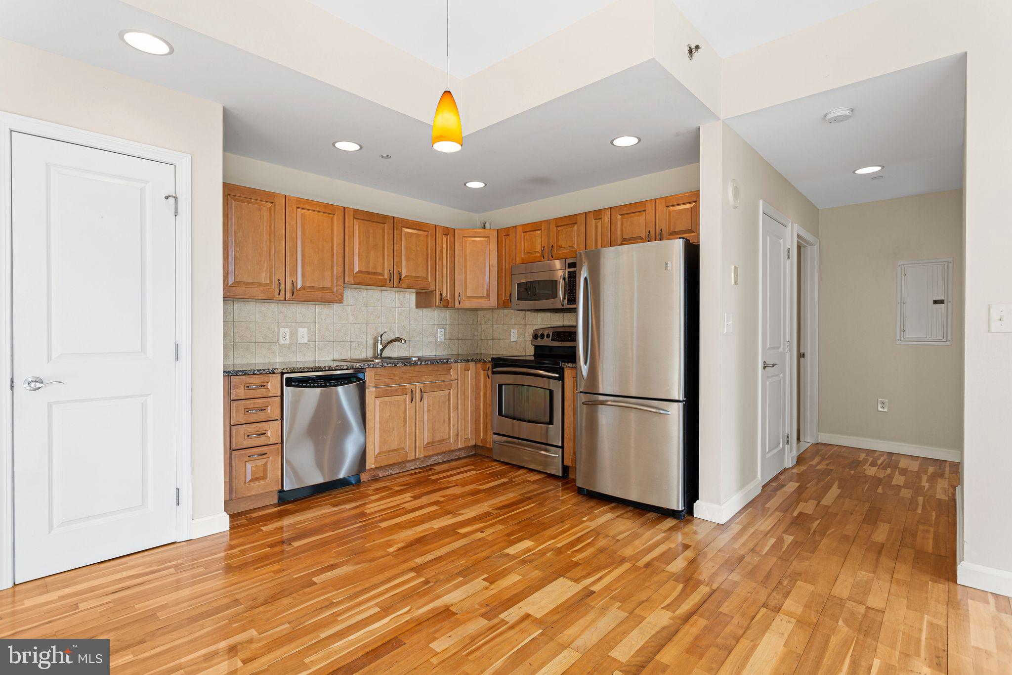 901 North Penn Street, Unit R704 Philadelphia, PA 19123 - Photo 7 of 41 a kitchen with granite countertop a refrigerator and a stove top oven