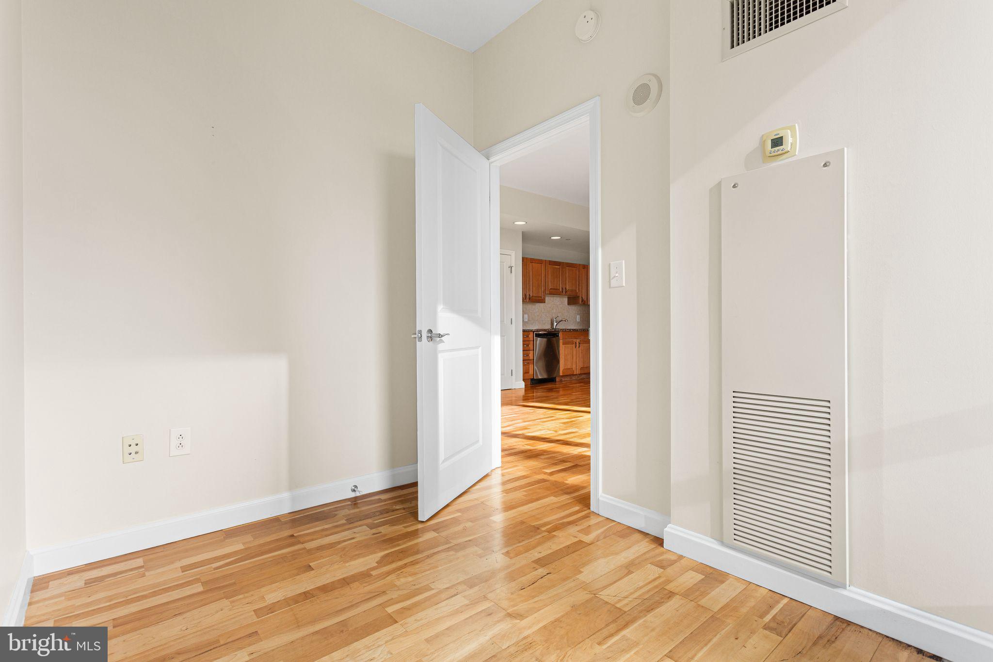 901 North Penn Street, Unit R704 Philadelphia, PA 19123 - Photo 10 of 41 an empty room with wooden floor and a bathroom