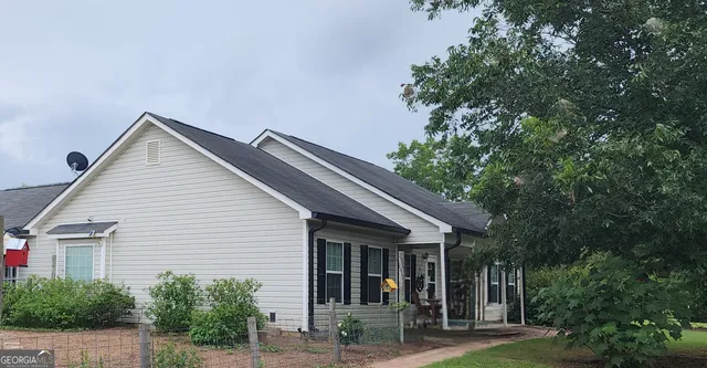 a view of a house with backyard and a tree
