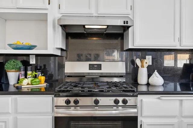 a stove top oven sitting inside of a kitchen