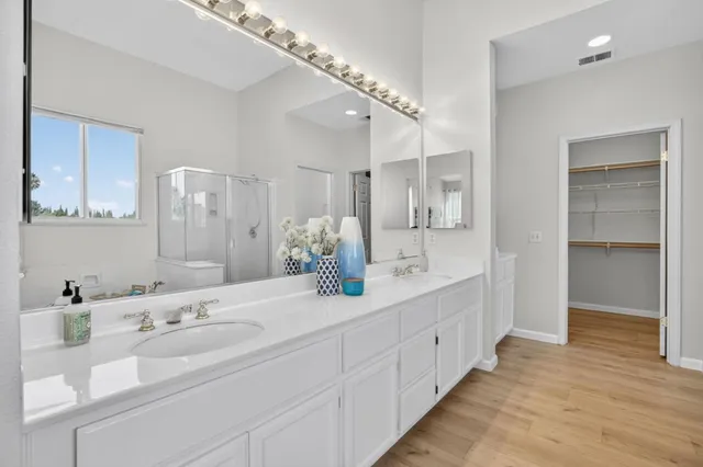 a bathroom with double vanity sinks and a mirror