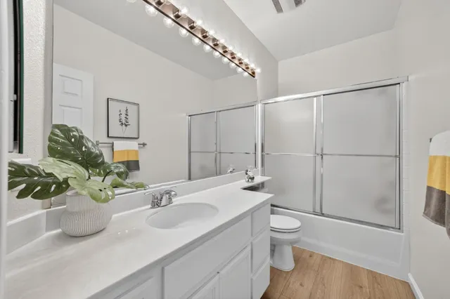 a bathroom with a sink a toilet and shower