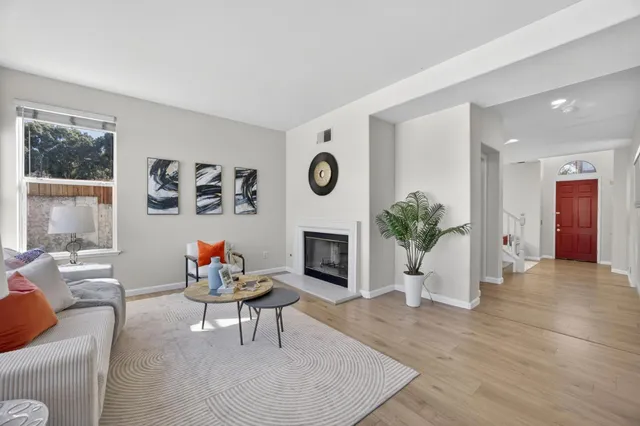 a living room with furniture a fireplace and a large window