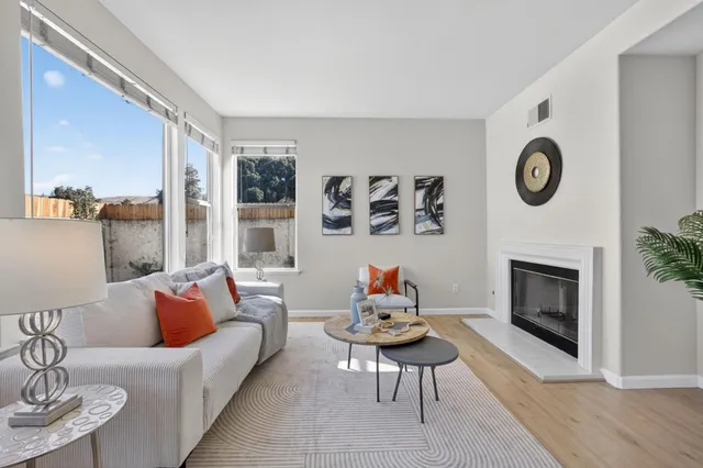 a living room with furniture a fireplace and a large window