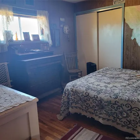 a bedroom with a bed and painting on the wall