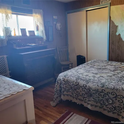 a bedroom with a bed and painting on the wall