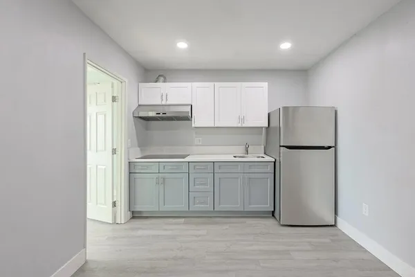 a kitchen with a refrigerator sink and cabinets