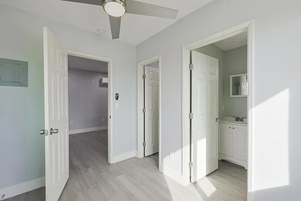 a view of a hallway with wooden floor and a cabinet