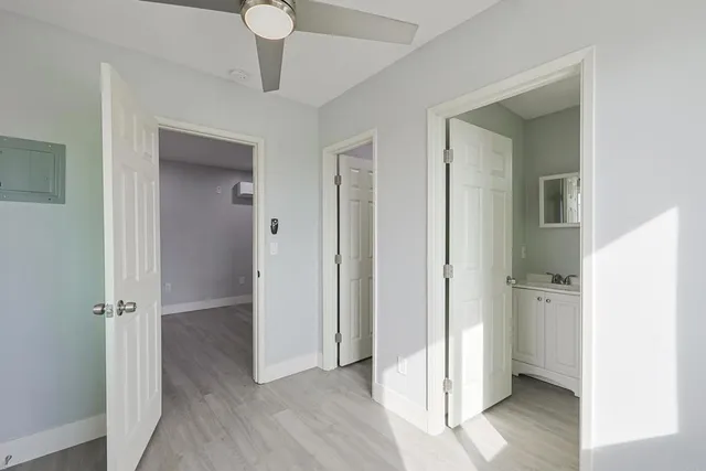 a view of a hallway with wooden floor and a cabinet