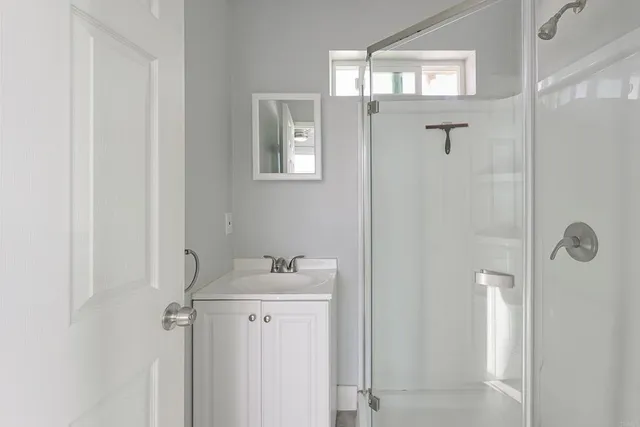 a bathroom with a sink mirror and shower