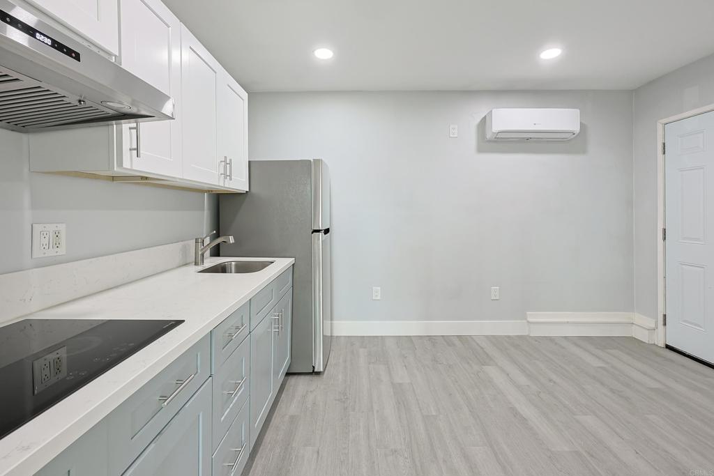 3774 Clavelita Street San Diego, CA 92154 - Photo 8 of 18 an empty room with wooden floor and sink
