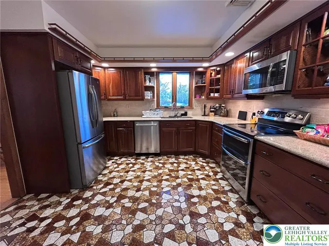 a large kitchen with stainless steel appliances granite countertop a sink stove and refrigerator