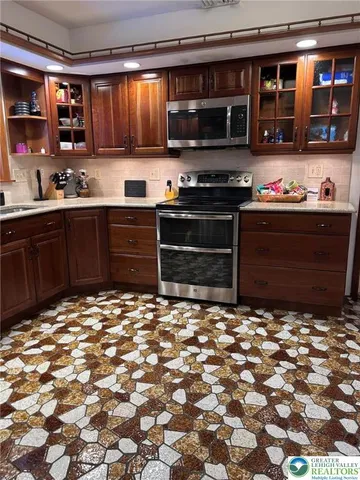 a kitchen with stainless steel appliances kitchen island granite countertop a stove and cabinets