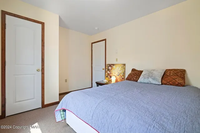 a bedroom with a bed a mirror and a window