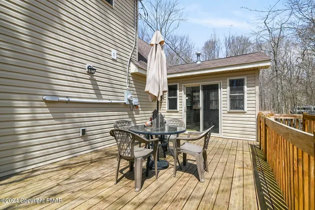 a view of a patio with table and chairs and wooden floor